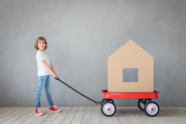 happy child playing into new home kid having fun indoor moving house day and express delivery