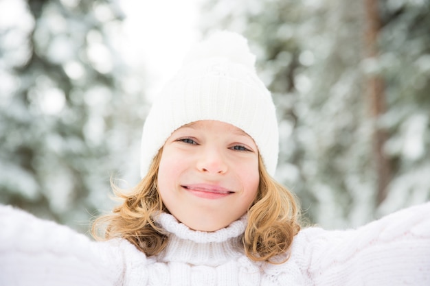 Happy child playing outdoor. Kid having fun in winter park. Healthy active lifestyle concept