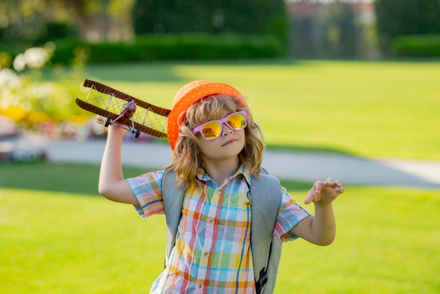 Happy child playing outdoor Kid having fun with toy paper wings