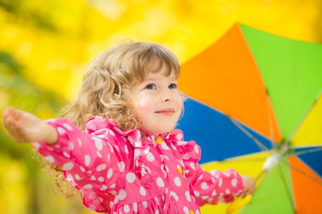 Happy child playing outdoors in autumn park