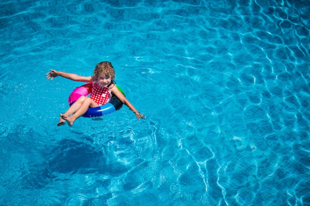 Happy child playing in swimming pool  Top view portrait