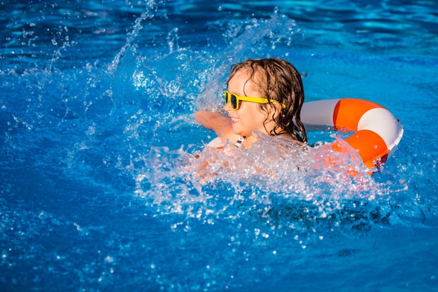 Happy child playing in swimming pool