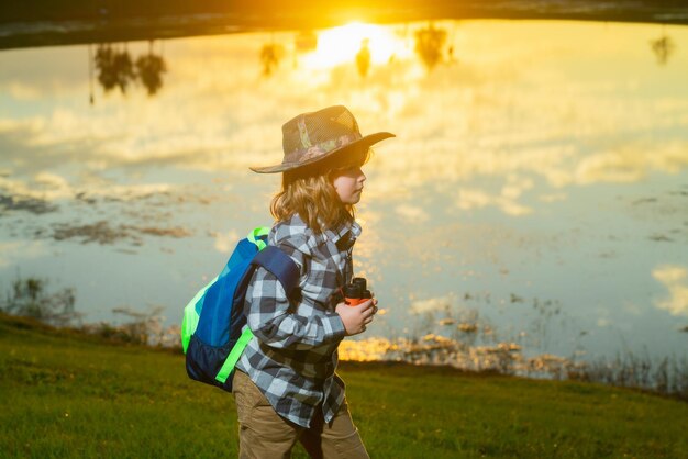 双眼鏡で遊ぶ幸せな子供 探検と冒険 探検するバックパックを持つ子供の男の子