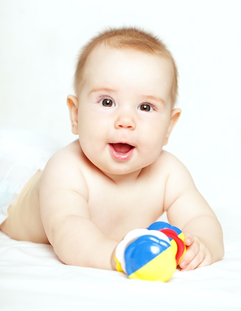 Happy child playing with ratte - baby, 5 months old