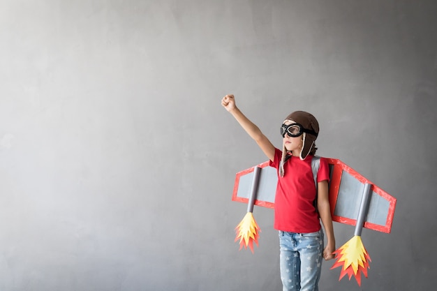 Happy child playing with toy jetpack