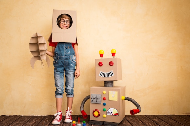 Happy child playing with toy robot at home. Innovation technology and success concept