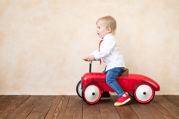 Happy child riding toy car