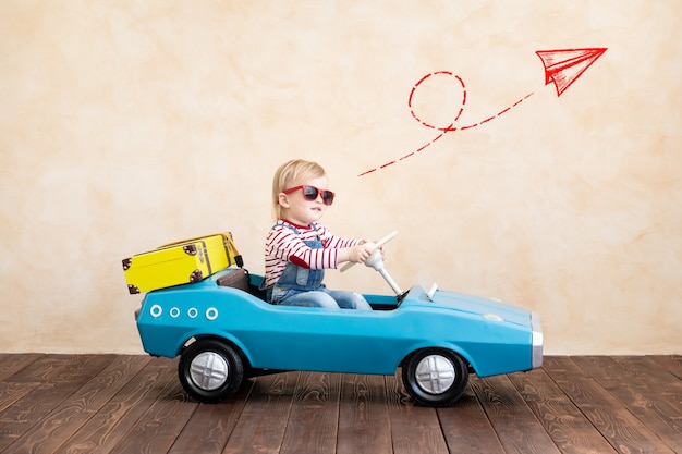 Happy child riding toy vintage car