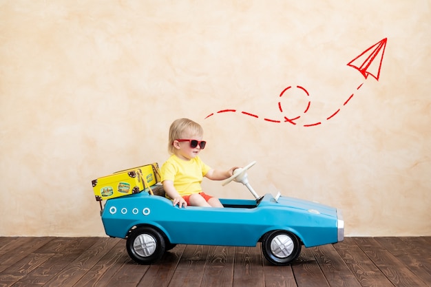 Happy child riding toy vintage car