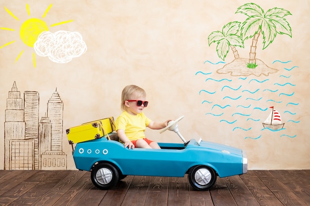 Happy child riding toy vintage car