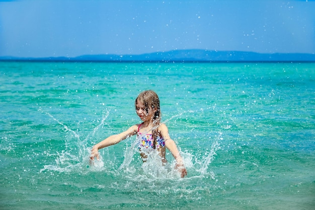 ギリシャの海で幸せな子供は自然の中で遊ぶ