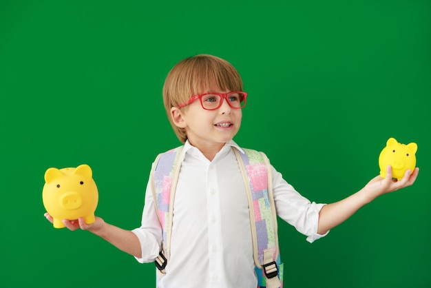 Happy child student against green chalkboard