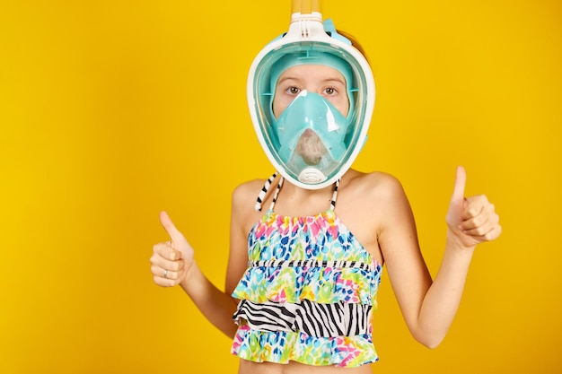 Happy child teenager girl with in swimsuit and snorkeling mask in studio