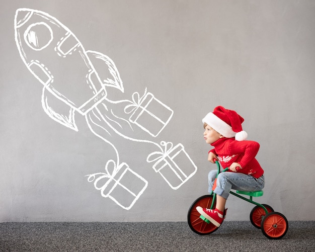 Happy child wearing Christmas costume Kid riding bike