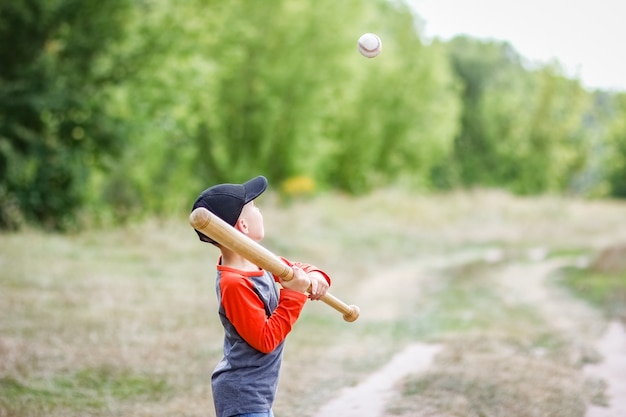 Photo a happy child with baseball bat on nature concept in park