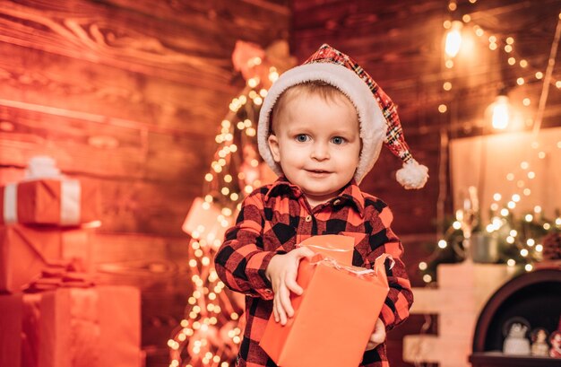 Happy child with christmas gift box surprise present box a little boy in warm clothes merry