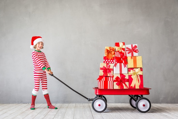 Happy child with Christmas gift. Kid having fun at home