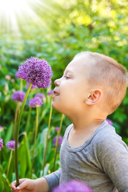 A Happy child with flowers sniffing in the park on nature travel