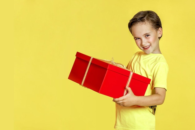 Happy child with gifts on a yellow background