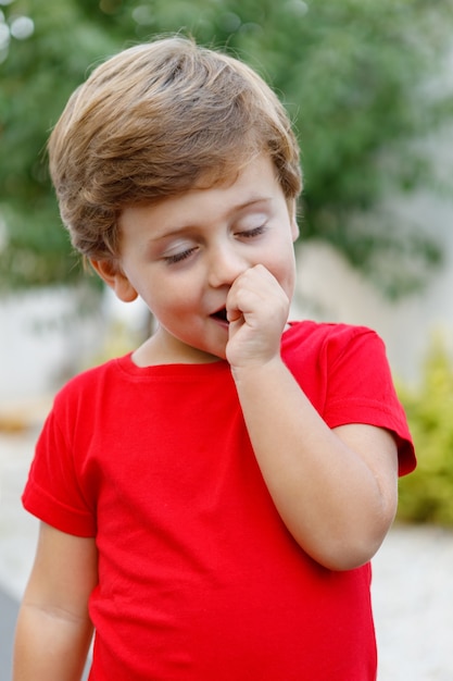 Happy child with red t-shirt in the garden 