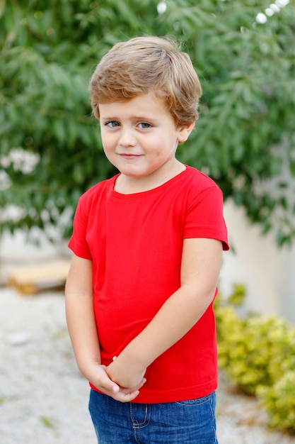 Happy child with red t-shirt in the garden 