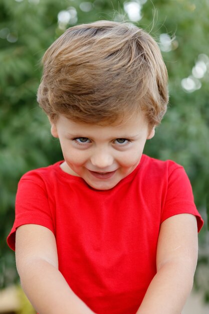 Happy child with red t-shirt in the garden 