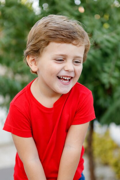 Happy child with red t-shirt in the garden 