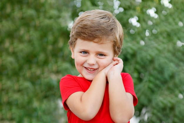 Bambino felice con la maglietta rossa nel giardino