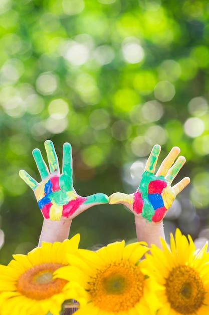 Photo happy child with smiley on hands against green spring background