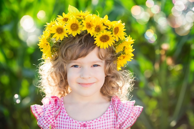 Happy child with sunflowers in spring field