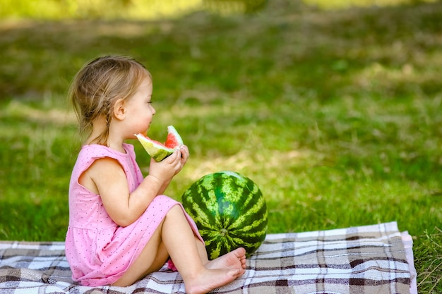 Happy child with watermelon in nature