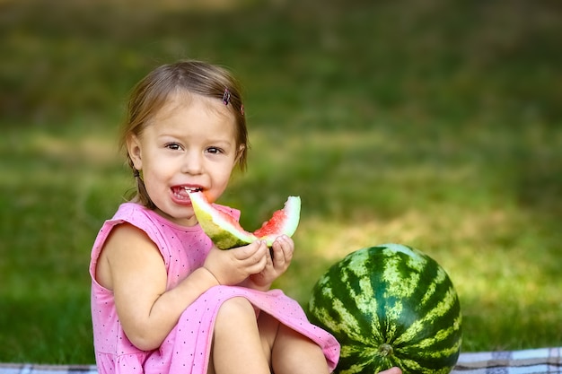 Happy child with watermelon in nature