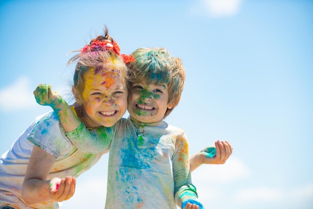 Happy childhood kids playing colours with smeared face holi festival of colors child girls and boy c