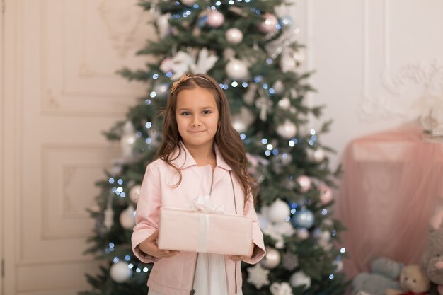 Happy childhood, magical Christmas tale. Little princess with Santa's present for Christmas.