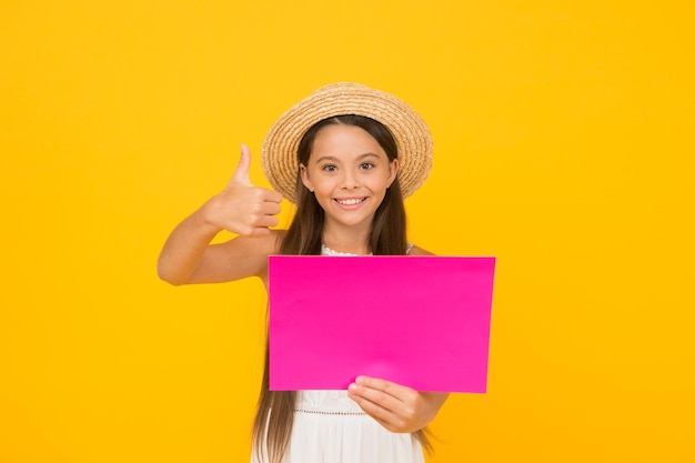 Happy childhood summer holiday and vacation kid seasonal fashion sales carefree beauty show paper sheet copy space kid in straw hat with thumb up little child advertises beach activity