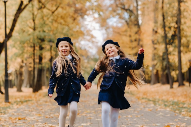 Happy children are running in a beautiful autumn park