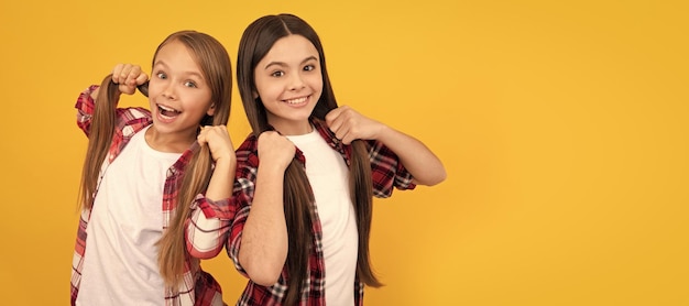 Happy children casual checkered shirt hold long straight hair yellow background hair Kid girl hair