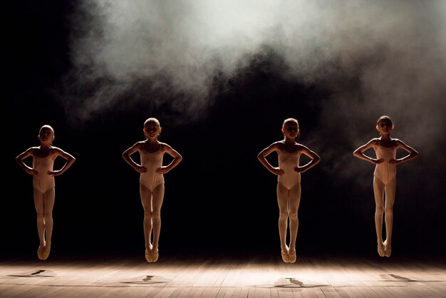 Happy children doing ballet jump