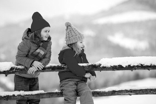 Happy children friends in snow little girl and boy having fun at winter day