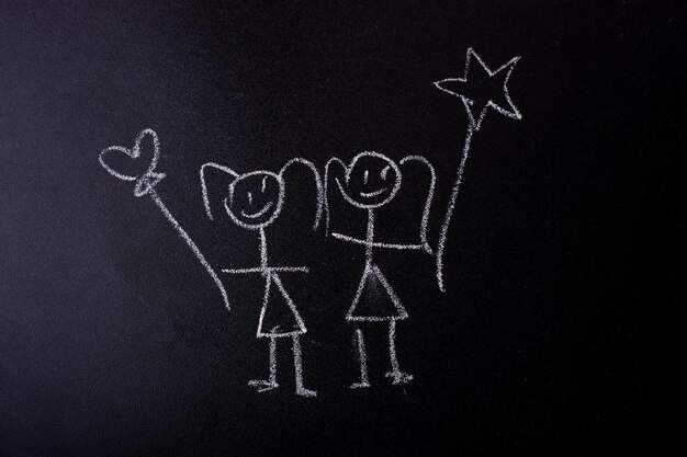 Photo happy children holding baloon drawn on chalk on a blackboard