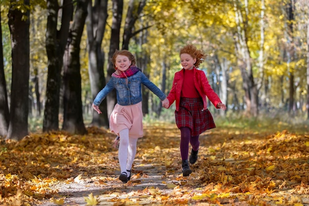 Photo happy children play in the autumn park on a warm sunny autumn day