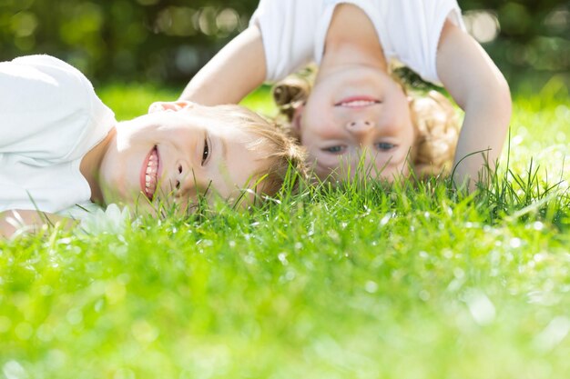 Happy children playing on green grass in spring park Environment protection concept