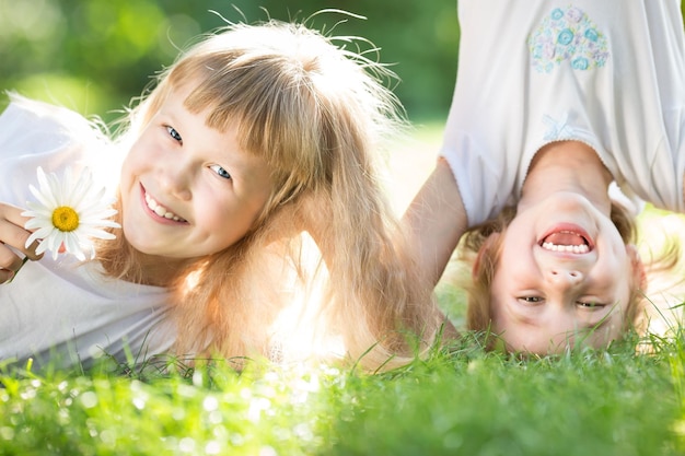 Foto bambini felici che giocano all'aperto nel parco di primavera