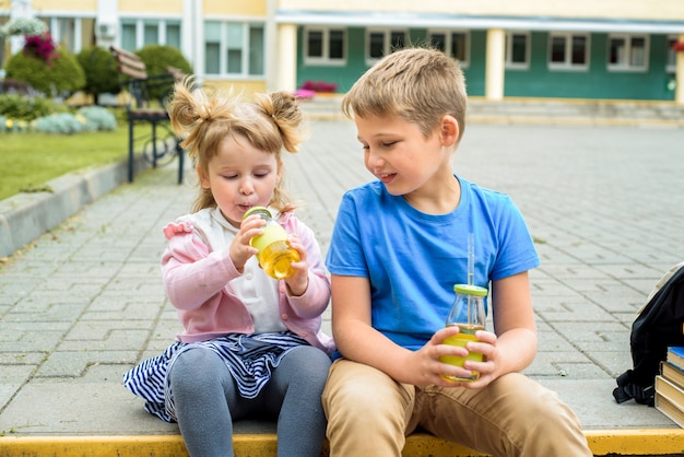 Bambini felici che giocano nel cortile della scuola al momento della giornata.