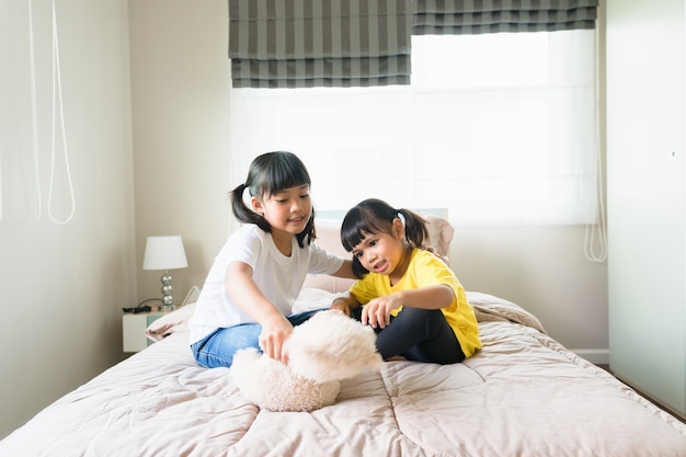 Happy children playing together in bedroom