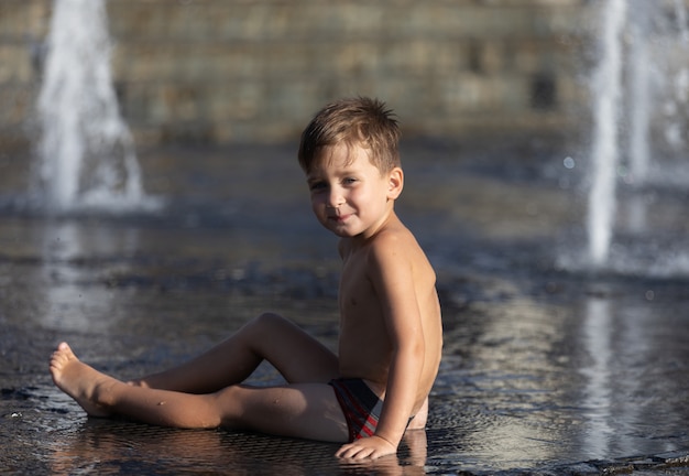 Happy children playing in a water fountain