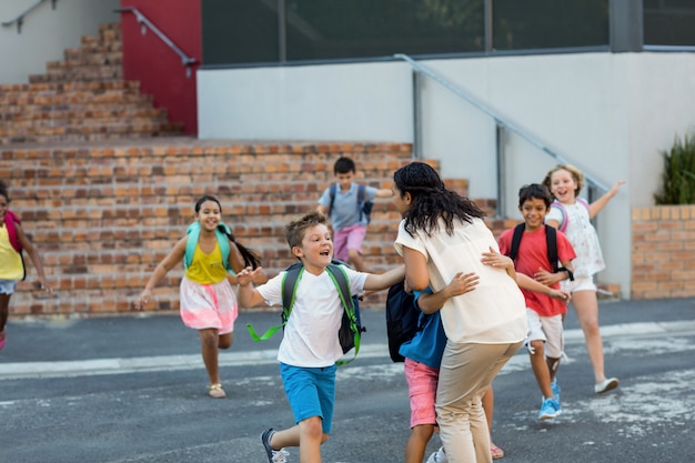 Photo happy children running towards teacher