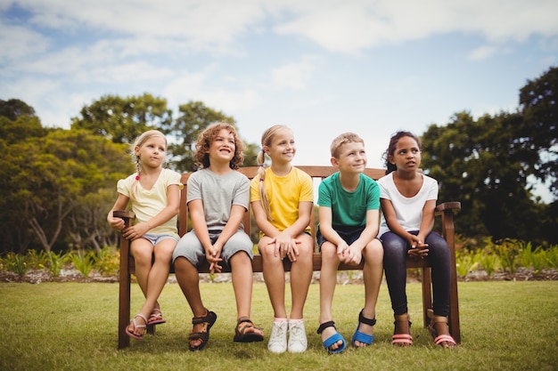 Happy children sitting on a bench