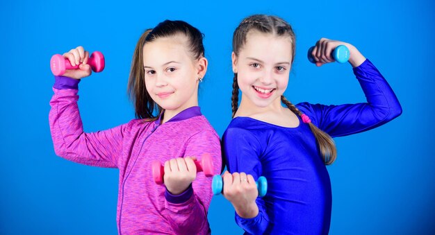 Happy children sportsman with barbell Sport success weight lifting for muscules Childhood activity Fitness diet for energy health workout of small girls hold dumbbell it is my power power girl