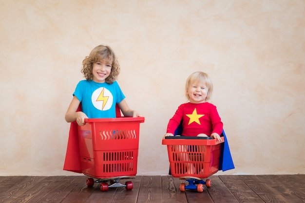 Happy children superheroes playing at home.